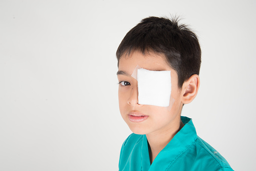 Boy with bandage over eye after accident