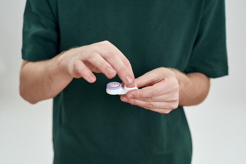 Man taking contact lenses from storage case